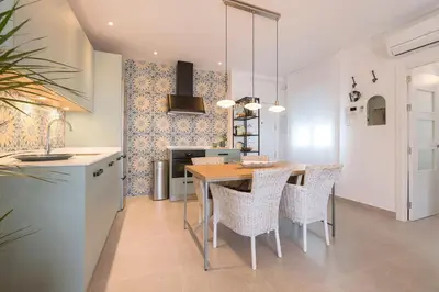 a kitchen and dining room with a table and chairs at Sol de Sanlúcar Ático centro Parking incluido in Sanlúcar de Barrameda