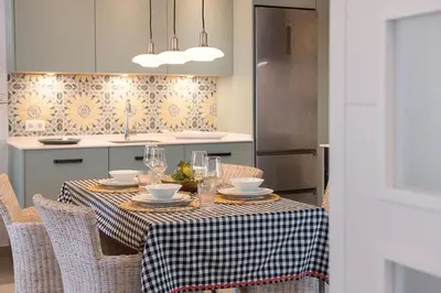 a kitchen with a table with chairs and a table cloth at Sol de Sanlúcar Ático centro Parking incluido in Sanlúcar de Barrameda