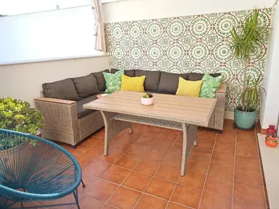 a patio with a couch and a table at Sol de Sanlúcar Ático centro Parking incluido in Sanlúcar de Barrameda