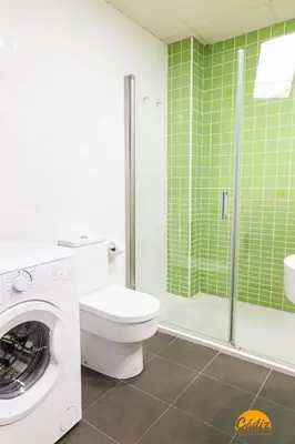 a bathroom with a washing machine and a toilet at Rincon del Mar - FREE PARKING by Cadiz Time in Cádiz