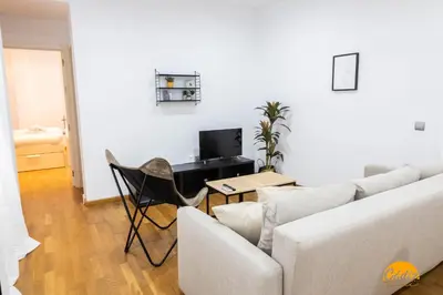 a living room with a couch and a table with a computer at Rincon del Mar - FREE PARKING by Cadiz Time in Cádiz