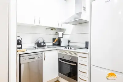 a kitchen with white cabinets and a stove top oven at Rincon del Mar - FREE PARKING by Cadiz Time in Cádiz