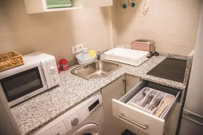 a small kitchen with a sink and a microwave at Apartamento Me'ncanta Jeré in Jerez de la Frontera