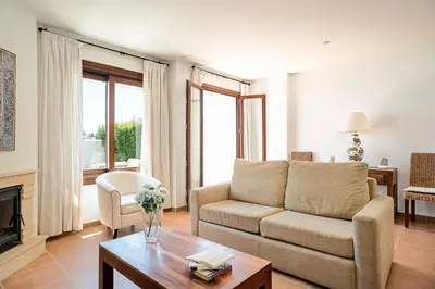 a living room with a couch and a table at Casa Poniente en playa Fuente del Gallo in Conil de la Frontera
