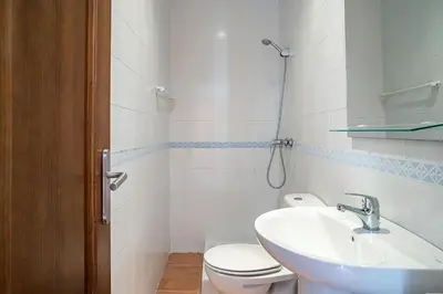 a bathroom with a white toilet and a sink at Casa Poniente en playa Fuente del Gallo in Conil de la Frontera