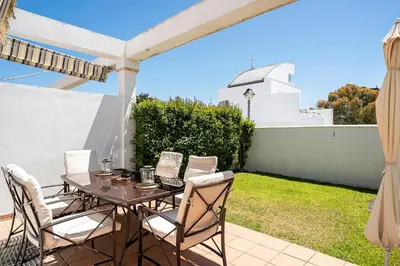 a table and chairs on the patio of a house at Casa Poniente en playa Fuente del Gallo in Conil de la Frontera