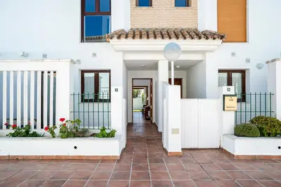 a house with white walls and a walkway at Casa Poniente en playa Fuente del Gallo in Conil de la Frontera