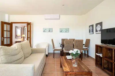 a living room with a couch and a tv at Casa Poniente en playa Fuente del Gallo in Conil de la Frontera