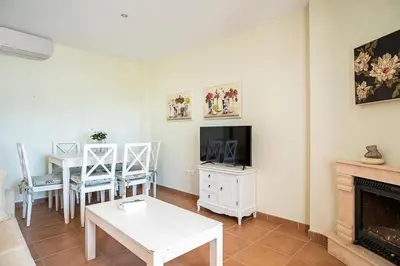 a living room with a white table and a tv at Casa Levante en playa Fuente del Gallo in Conil de la Frontera