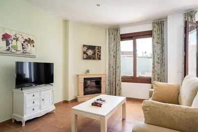 a living room with a tv and a fireplace at Casa Levante en playa Fuente del Gallo in Conil de la Frontera