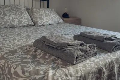 a bed with two towels sitting on top of it at Apartamento Doña Lola in Jerez de la Frontera