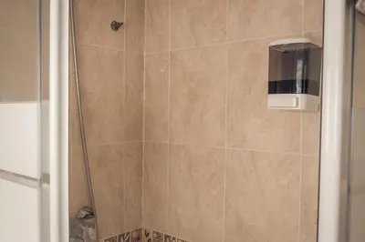 a bathroom with a shower with a tiled wall at Apartamento Doña Lola in Jerez de la Frontera