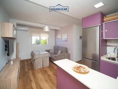 a kitchen and living room with purple cabinets at Apartamento Aránzazu playa in Sanlúcar de Barrameda