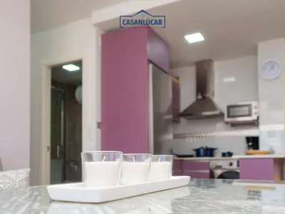 a table with two glasses on a counter in a kitchen at Apartamento Aránzazu playa in Sanlúcar de Barrameda