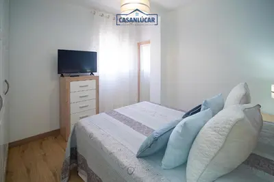 a bedroom with a bed with a television on a dresser at Apartamento Aránzazu playa in Sanlúcar de Barrameda