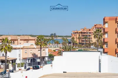 a view of a city with palm trees and buildings at Apartamento Aránzazu playa in Sanlúcar de Barrameda