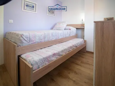 two bunk beds in a room with wooden floors at Apartamento Aránzazu playa in Sanlúcar de Barrameda