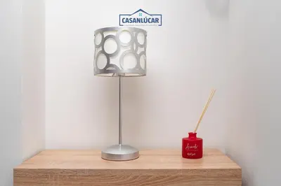 a lamp sitting on top of a wooden table at Apartamento Aránzazu playa in Sanlúcar de Barrameda