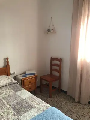 a bedroom with a bed and a chair and a desk at Casa en primera línea de playa in Rota