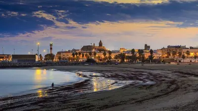 a view of a beach with buildings in the background at Casa en primera línea de playa in Rota