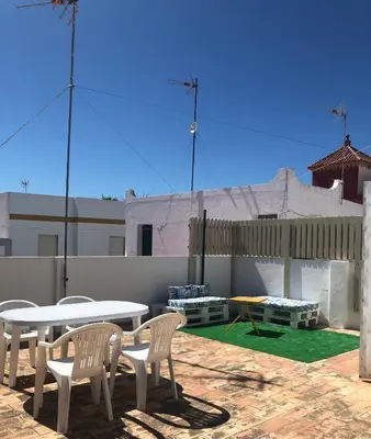 a patio with a table and chairs on a patio at Casa en primera línea de playa in Rota