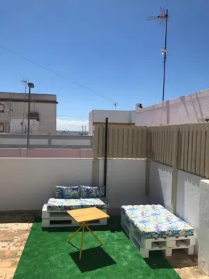two beds and a table on a roof at Casa en primera línea de playa in Rota