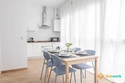 a dining room with a table and blue chairs at Casa del Pescador by LiveWork in Cádiz