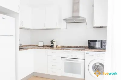 a white kitchen with a washer and dryer at Casa del Pescador by LiveWork in Cádiz