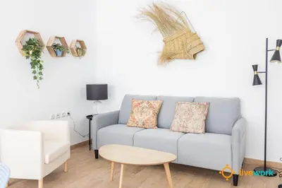 a living room with a blue couch and a table at Casa del Pescador by LiveWork in Cádiz