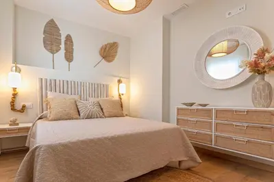 a bedroom with a bed with a dresser and a mirror at Genteel Home Mercado Central Terrace in Cádiz