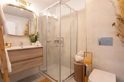 a bathroom with a shower and a toilet and a sink at Genteel Home Mercado Central Terrace in Cádiz