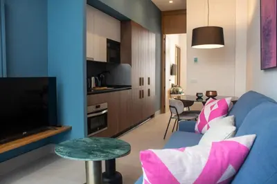 a living room with a blue couch and a tv at Guesting La Carbona in Jerez de la Frontera