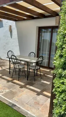 a patio with a table and chairs on a patio at Alojamiento El Drago - Sólo Familias y Parejas in Conil de la Frontera