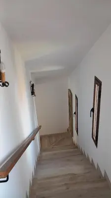 a hallway with two doors on the wall and wooden stairs at Alojamiento El Drago - Sólo Familias y Parejas in Conil de la Frontera