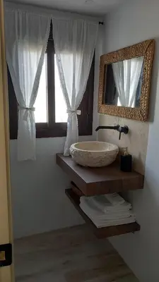 a bathroom with a sink and a mirror and a window at Alojamiento El Drago - Sólo Familias y Parejas in Conil de la Frontera