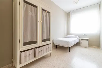 a bedroom with a bed and a dresser and a window at Allo Apartments Europa I Parking Piscina Padel 3 Habitaciones in Jerez de la Frontera