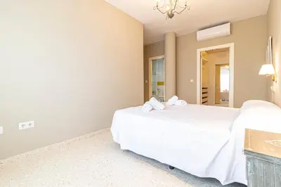 a bedroom with two beds and a chandelier at Allo Apartments Europa I Parking Piscina Padel 3 Habitaciones in Jerez de la Frontera