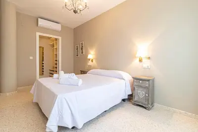 a bedroom with two beds with white sheets at Allo Apartments Europa I Parking Piscina Padel 3 Habitaciones in Jerez de la Frontera