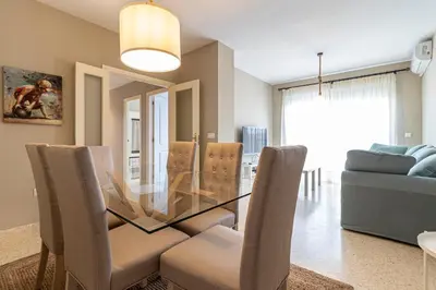 a dining room with a glass table and chairs at Allo Apartments Europa I Parking Piscina Padel 3 Habitaciones in Jerez de la Frontera