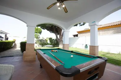 a pool table on acovered patio with a pool at Villa las Raices in Sanlúcar de Barrameda
