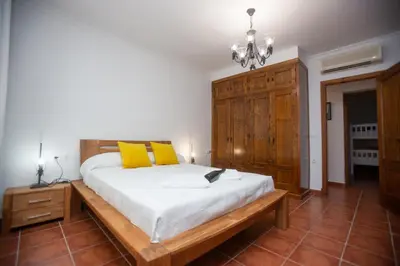 a bedroom with a large bed with yellow pillows at Villa las Raices in Sanlúcar de Barrameda