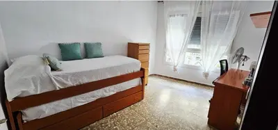 a bedroom with a bed and a desk and a window at Apartamento Soplos de vida in Cádiz