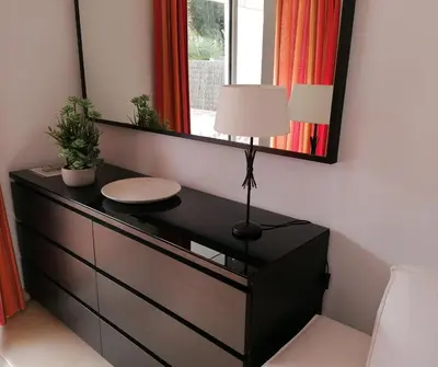 a dresser with a mirror and a lamp on it at Casa Lua in Conil de la Frontera