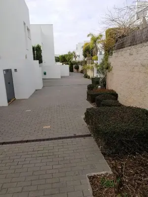 a brick walkway in front of a white building at Casa Lua in Conil de la Frontera