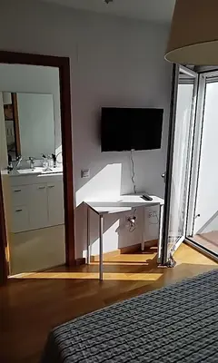 a room with a desk with a television and a sink at Casa Lua in Conil de la Frontera