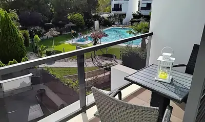 a balcony with a table and chairs and a swimming pool at Casa Lua in Conil de la Frontera