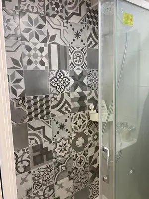 a bathroom with a shower with black and white tiles at Playa Apartamento Lidia in Cádiz