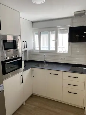 a kitchen with white cabinets and a sink at Playa Apartamento Lidia in Cádiz