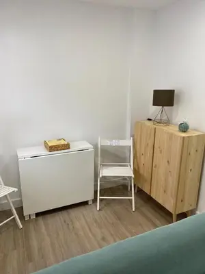 a room with a chair and a dresser and a table at Playa Apartamento Lidia in Cádiz