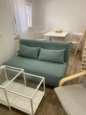 a living room with a blue couch and a table at Playa Apartamento Lidia in Cádiz